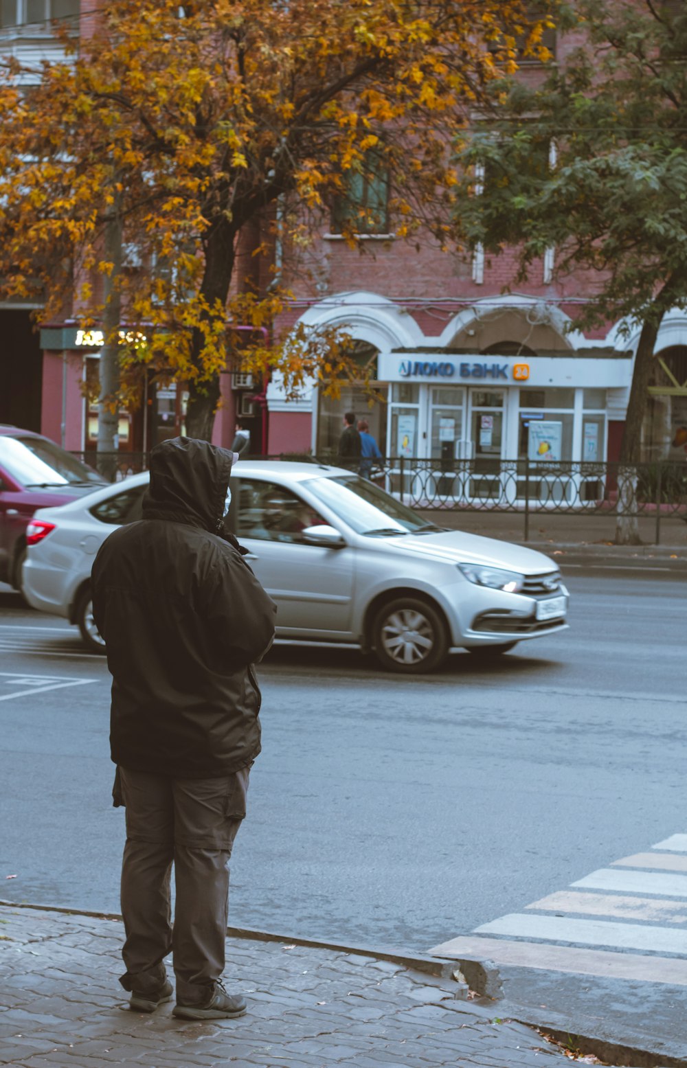 a man standing on the side of a road next to a traffic light