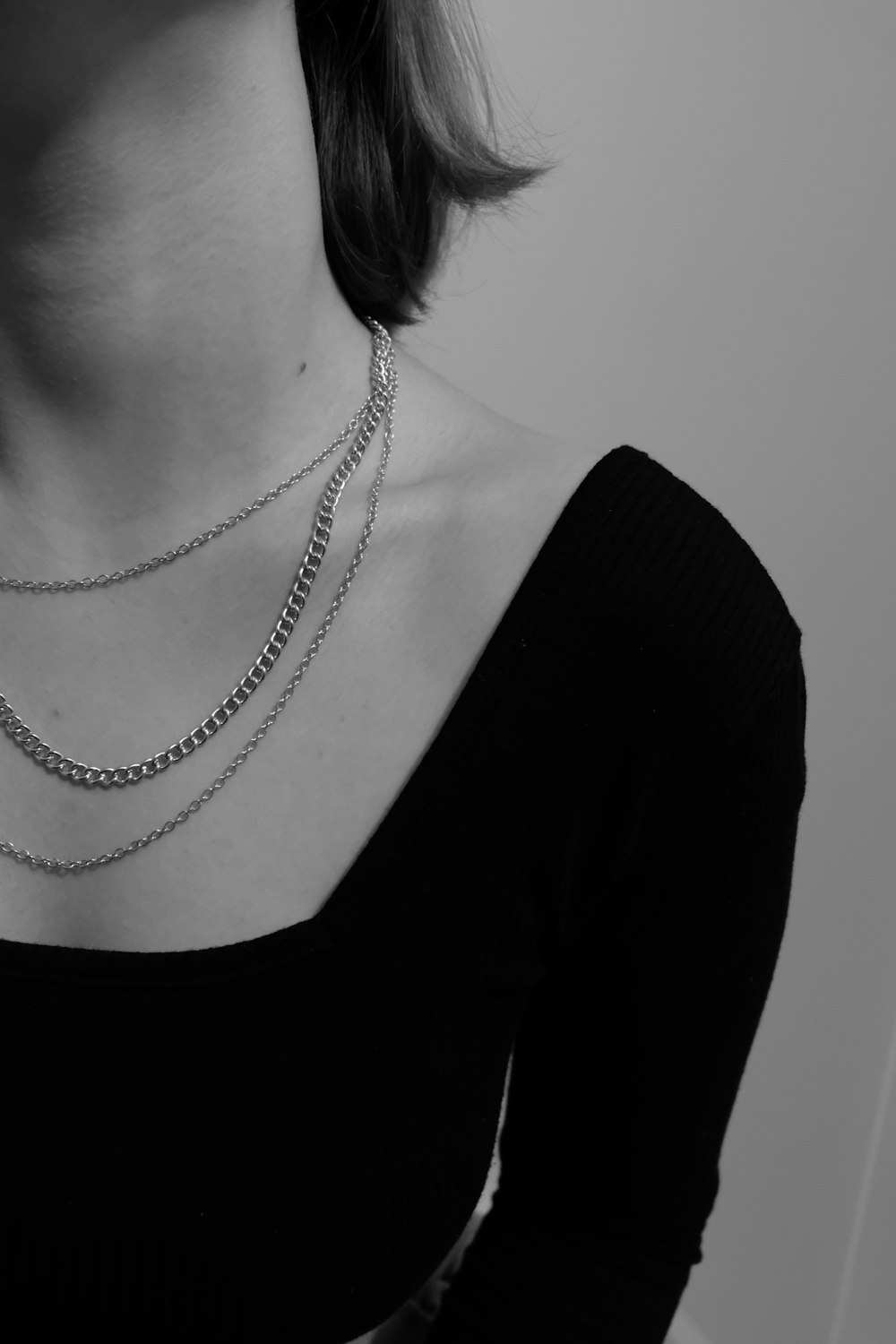 a woman wearing a black shirt and a silver chain necklace