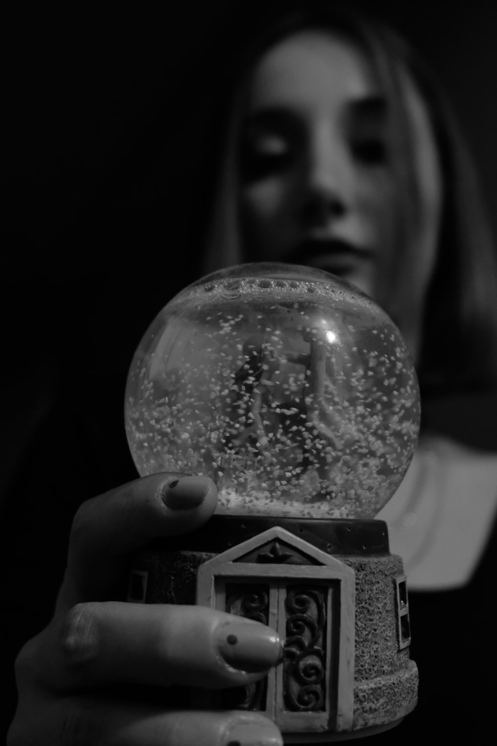 a woman holding a snow globe in her hand
