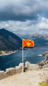 a flag on top of a hill overlooking a body of water
