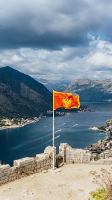 a flag on top of a hill overlooking a body of water