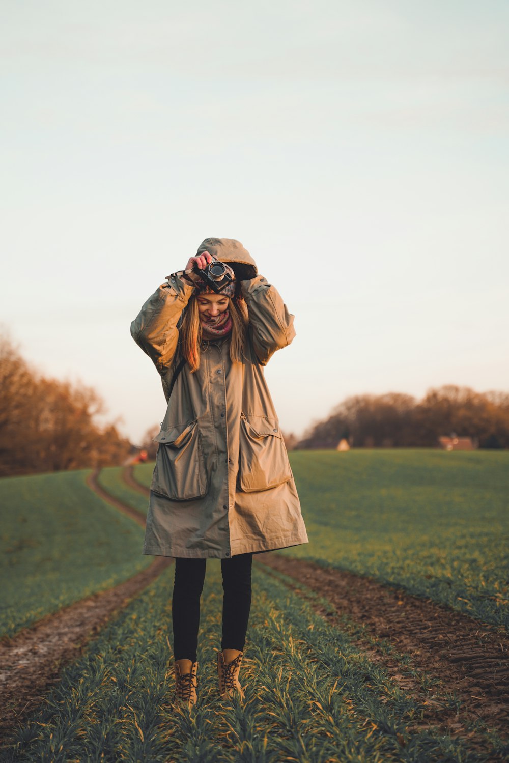 a woman standing in a field with a hat on her head