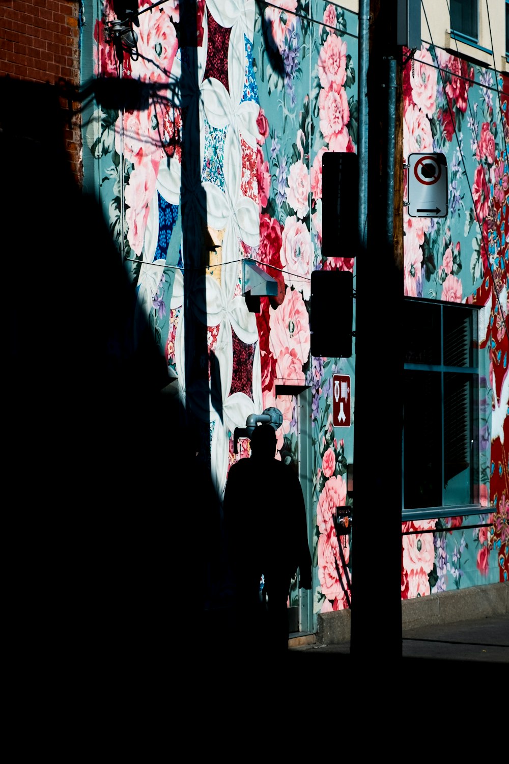 a person walking down a street next to a building