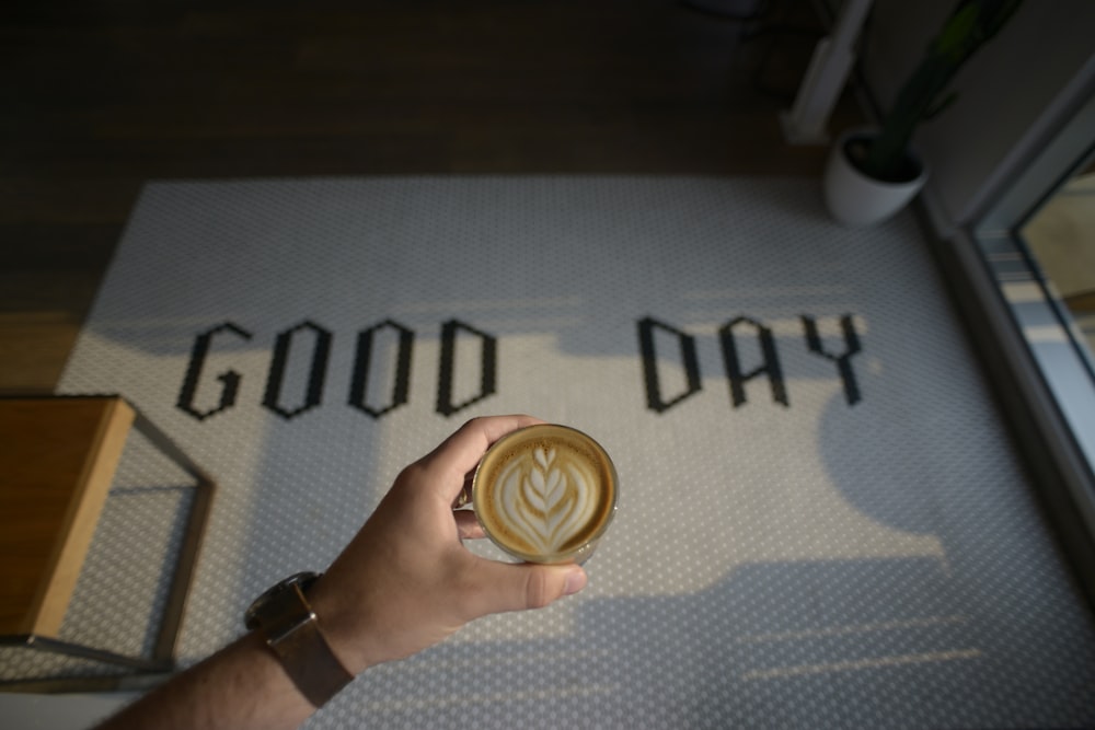 a person holding a cup of coffee in their hand