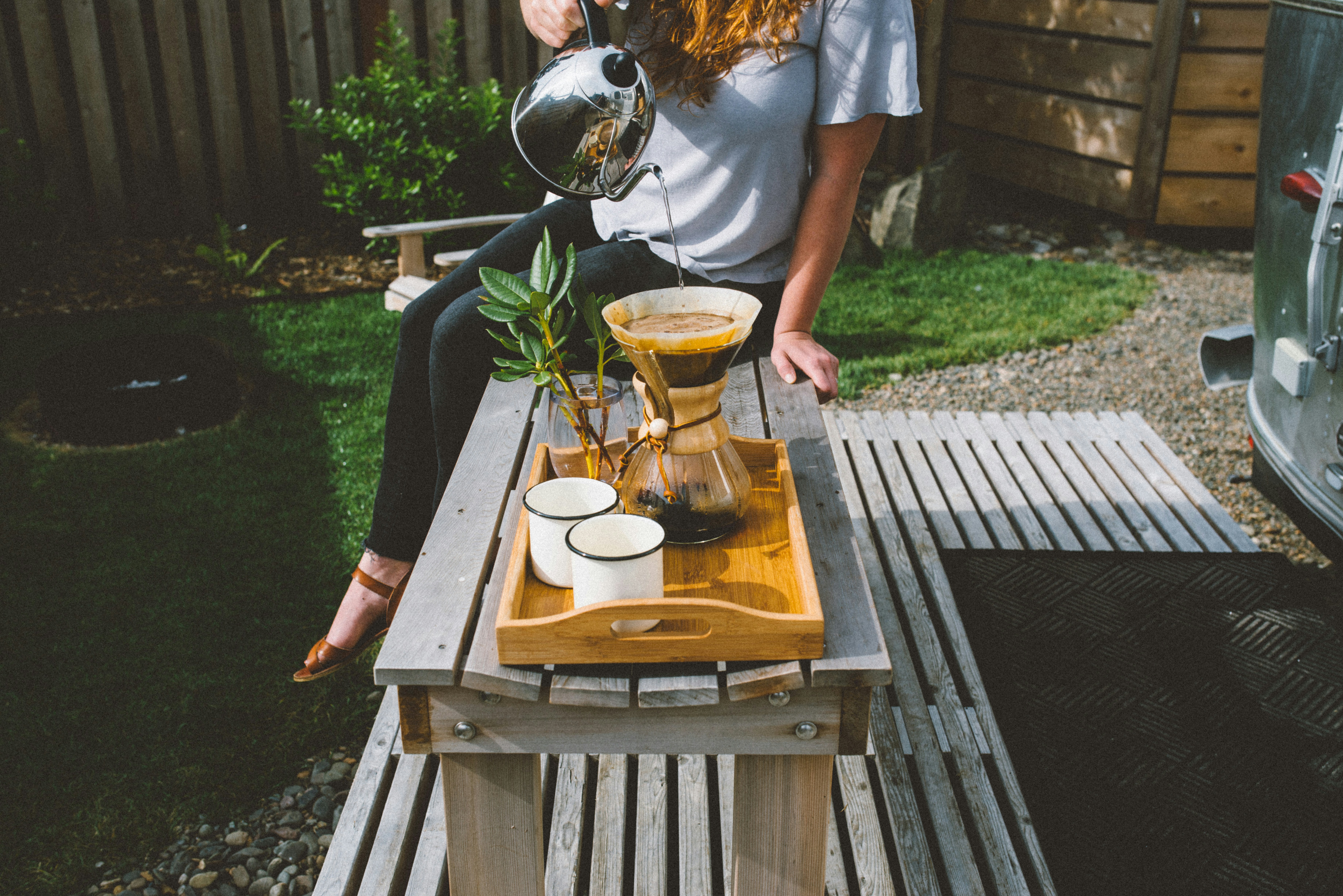 Woman with a pour-over coffee set on an outdoor table
