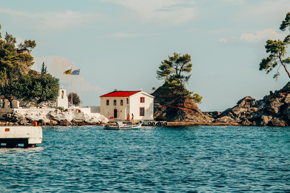 a small white house sitting on top of a body of water