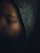 A moody portrait of a customer wearing a black oversized hoodie with red glowing accents under dim, cinematic lighting.