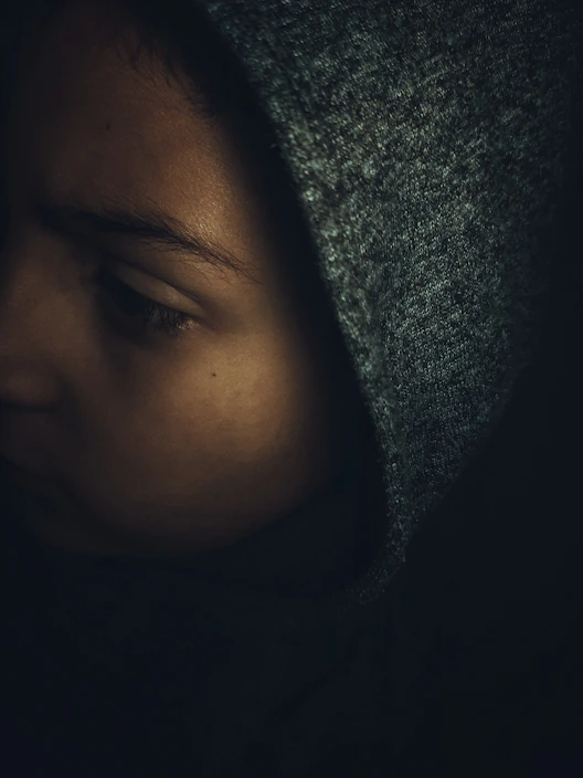 Close-up of the obsidian hoodie’s matte black textured fabric under soft lighting