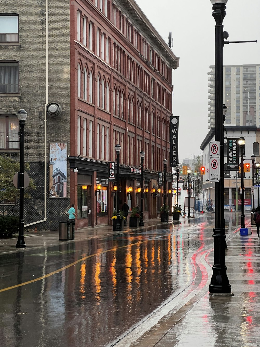 a wet city street with buildings and street lights