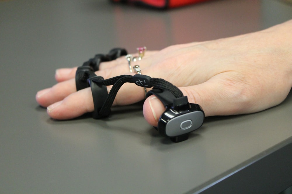 a person's hand on a table with a chain attached to it