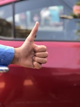 A satisfied customer giving a thumbs up next to a rented dumpster.