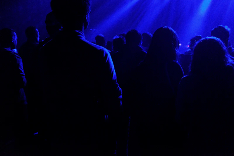 group of people mingling under blue lights