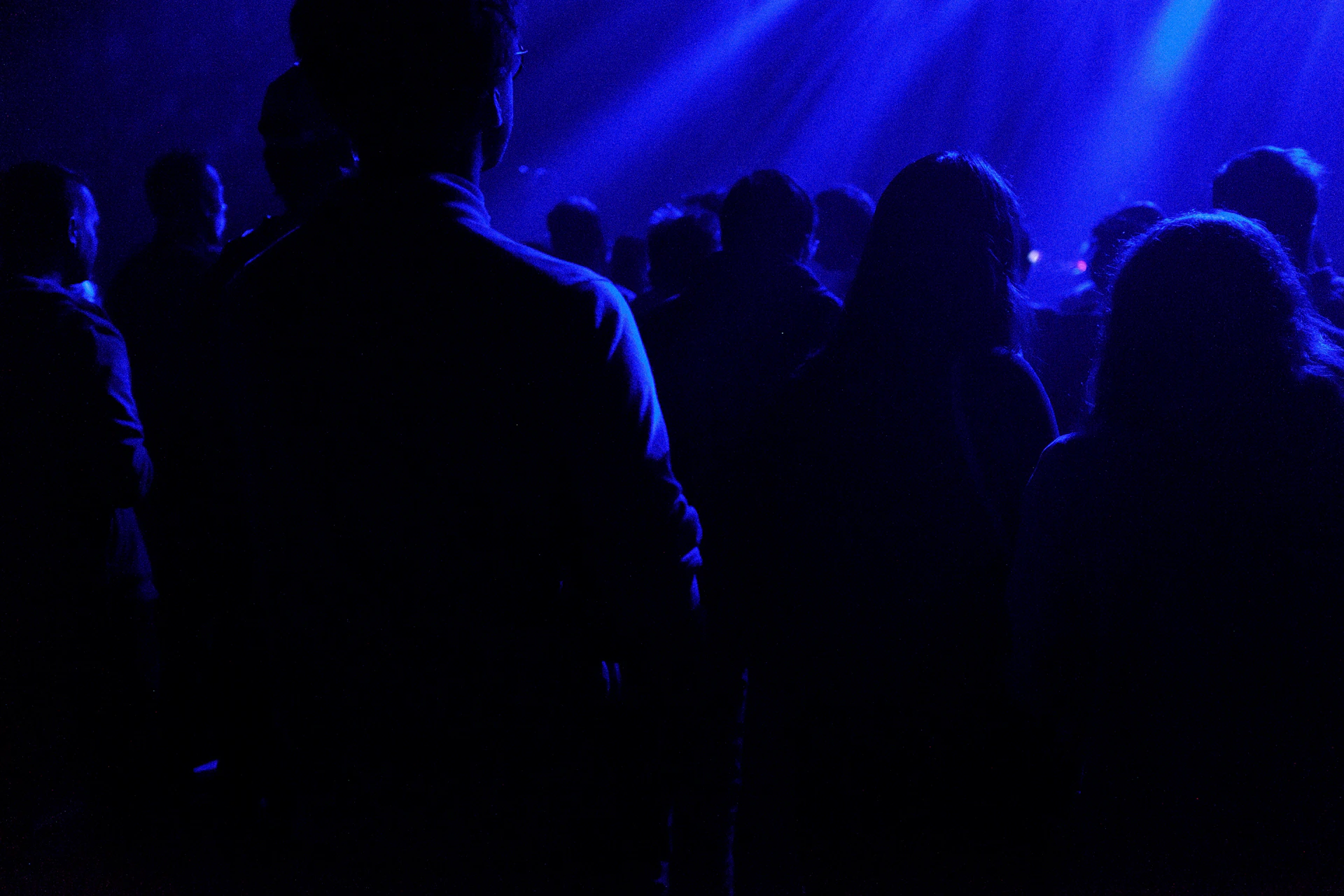 a group of people standing in front of a blue light