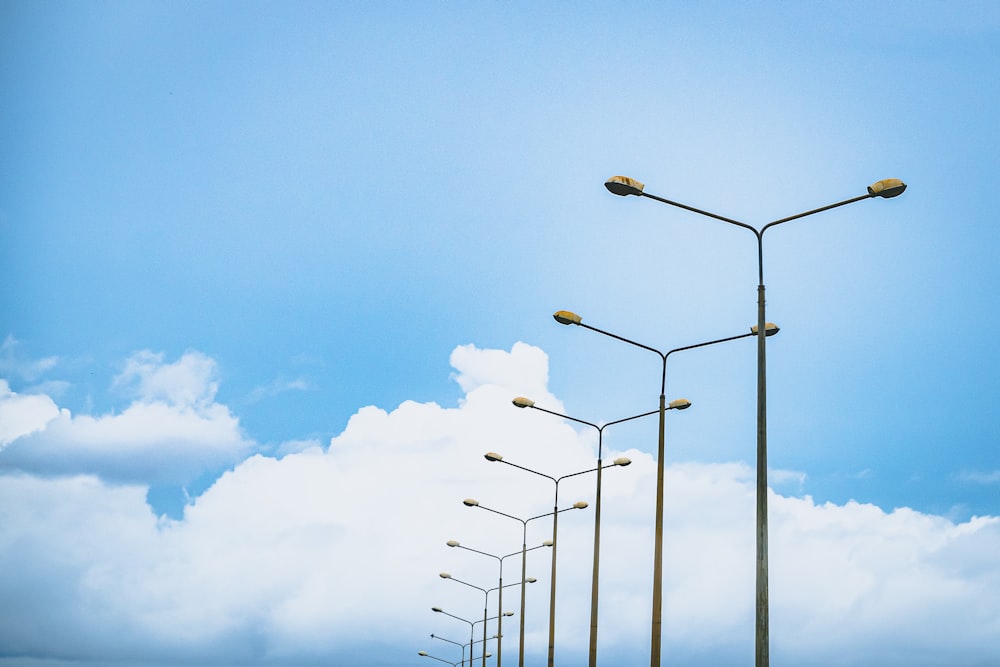 a row of street lights sitting on the side of a road