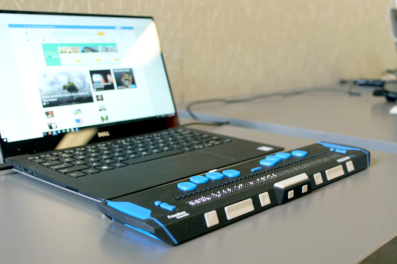 Laptop mit Braille-Display auf einem Schreibtisch — digitale Barrierefreiheit für Menschen mit Sehbeeinträchtigung.