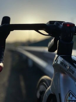 A close-up of a vintage bicycle's polished chrome handlebars with a soft-focus background of a sunlit park.