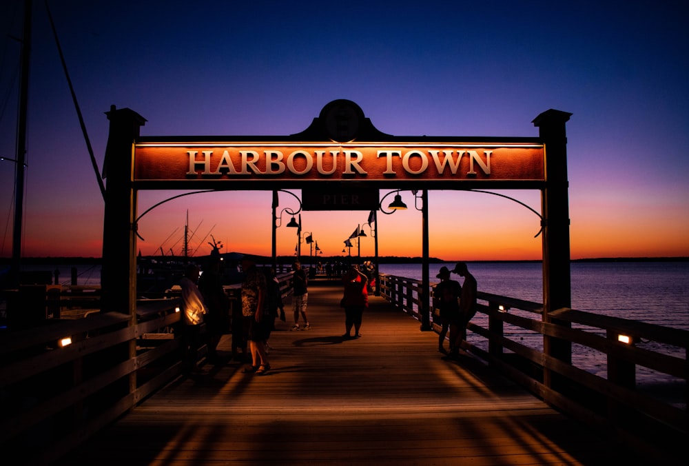 Eine Gruppe von Menschen, die bei Sonnenuntergang auf einem Pier stehen