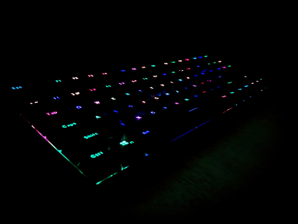 a computer keyboard lit up in the dark