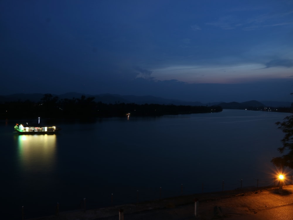 a boat floating on top of a lake at night