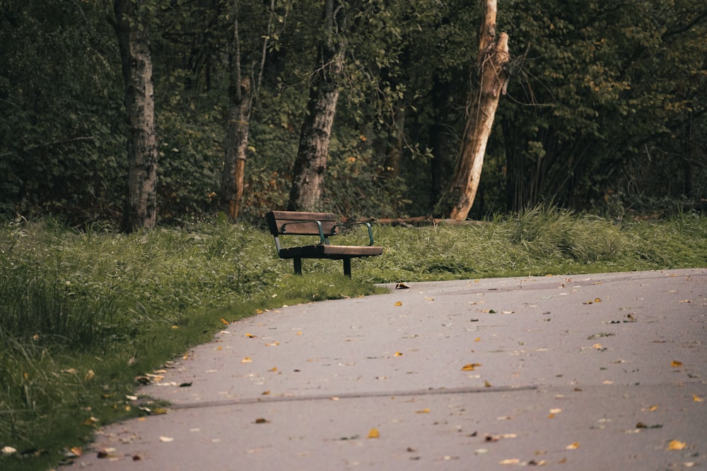 a park bench sitting on the side of a road