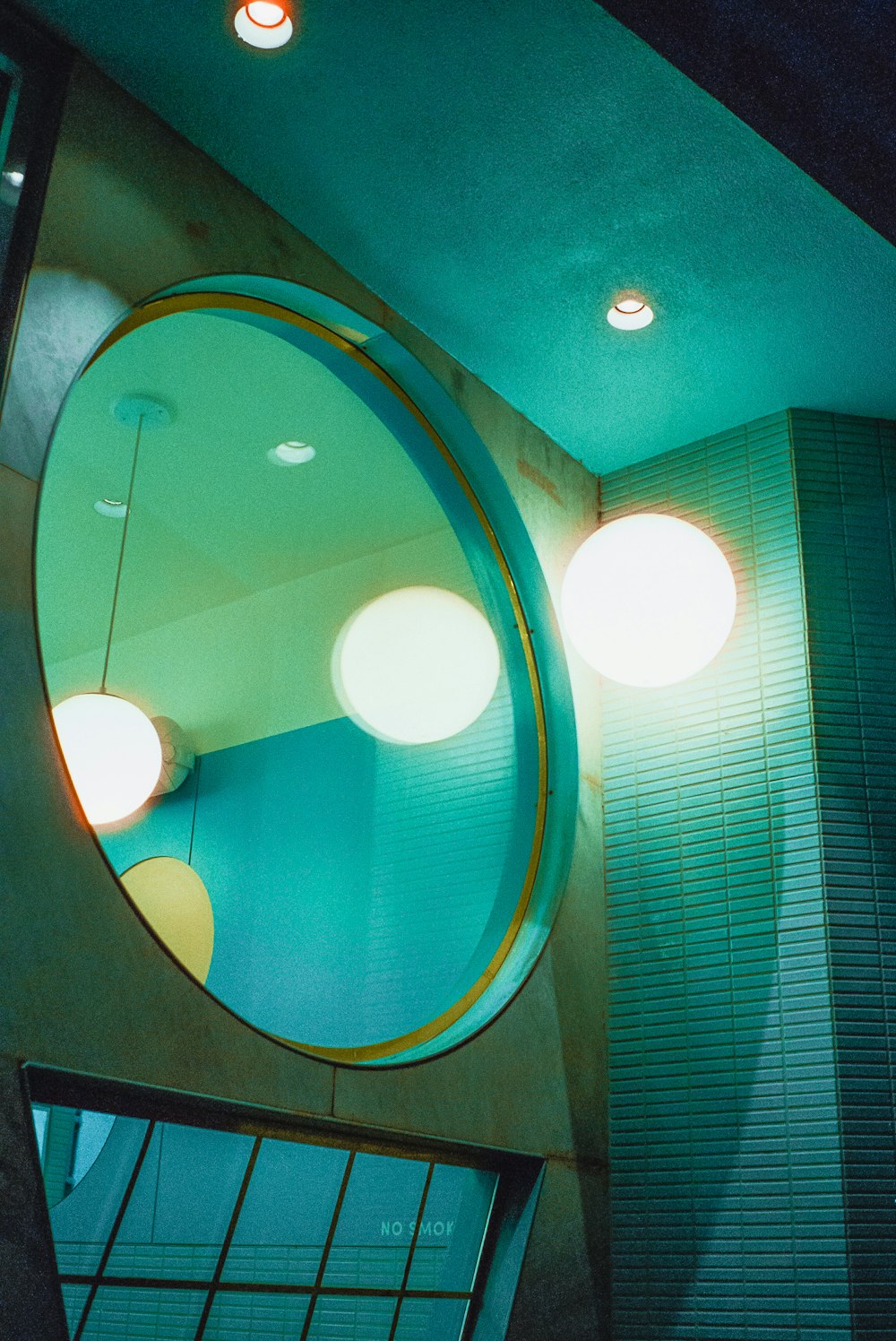 a circular mirror hanging from the side of a wall