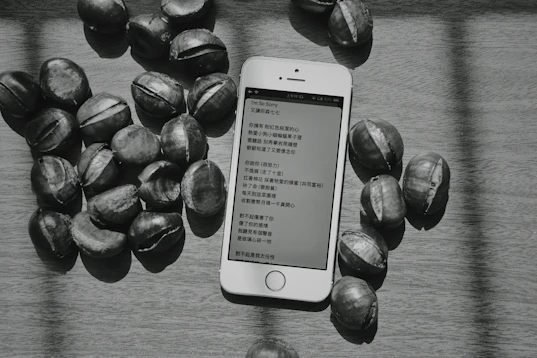 a cell phone sitting on top of a table next to nuts