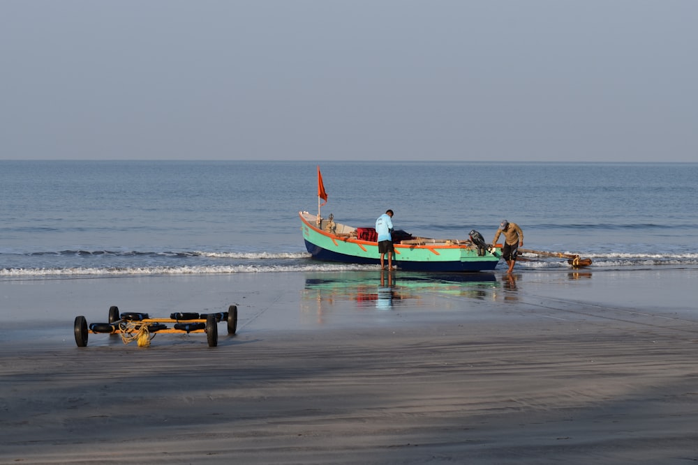 a boat sitting on top of a beach next to the ocean