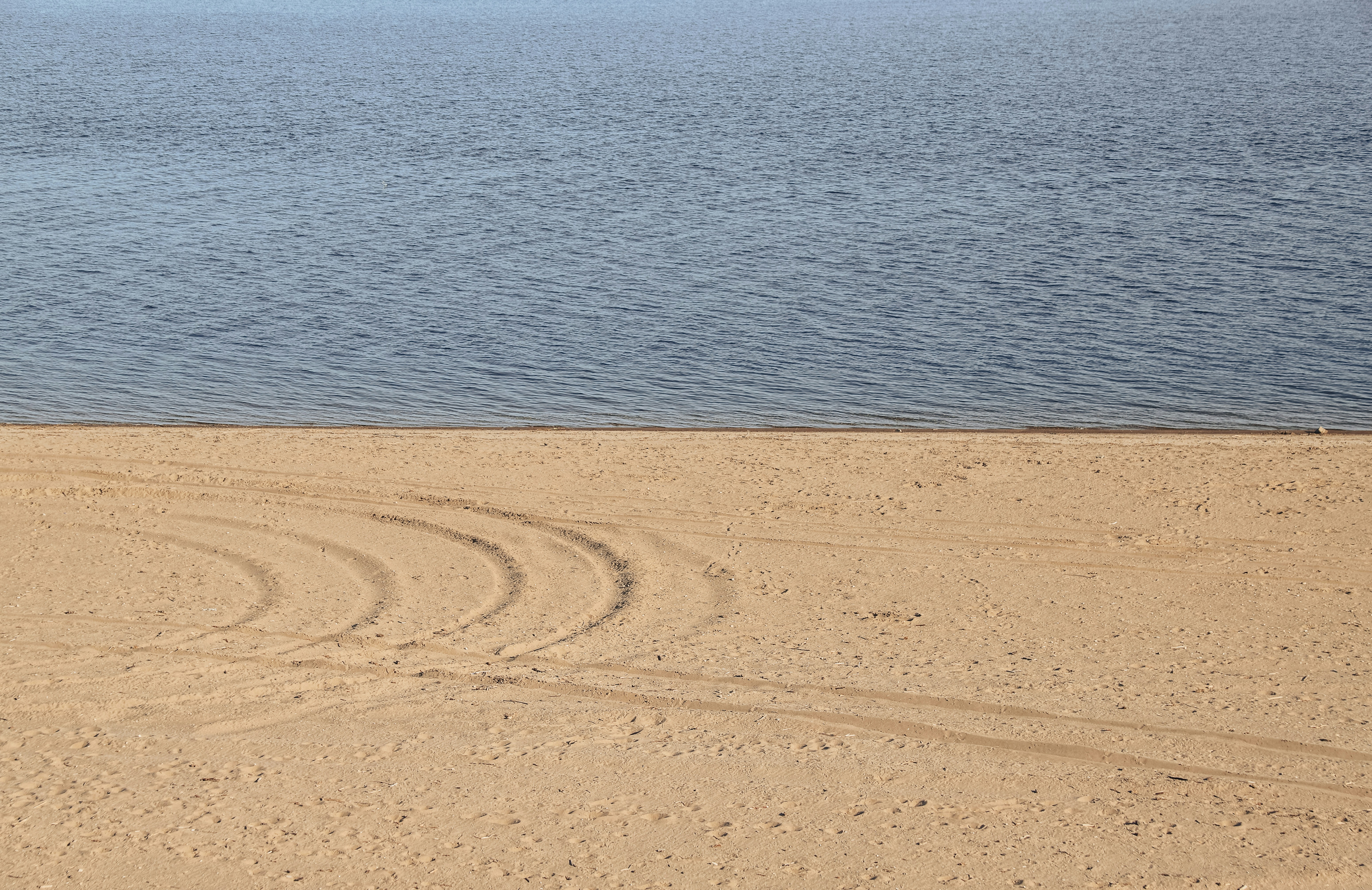 a man riding a horse on a beach next to the ocean