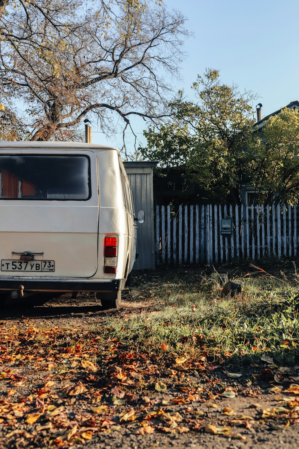 a white van parked next to a white fence