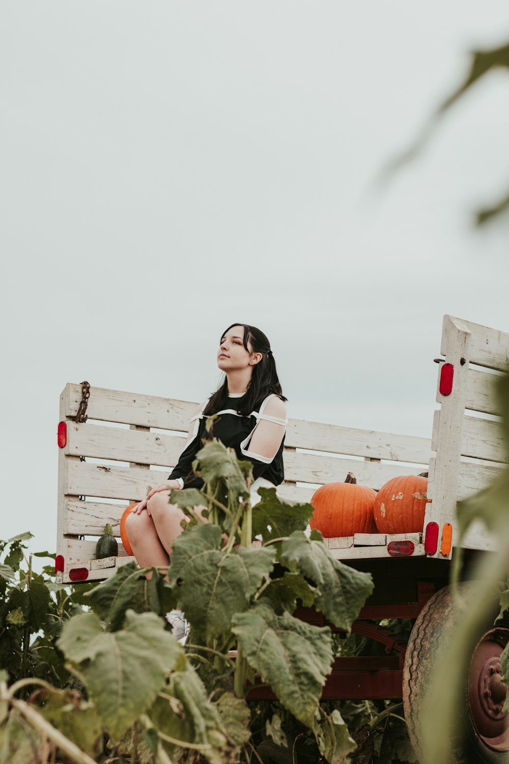 a woman sitting on top of a wooden bench