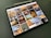 A tablet displaying a collection of interior design photos, showcasing rooms bathed in warm sunlight. The images feature modern, stylish living spaces with large windows, cozy seating, and decorative elements.