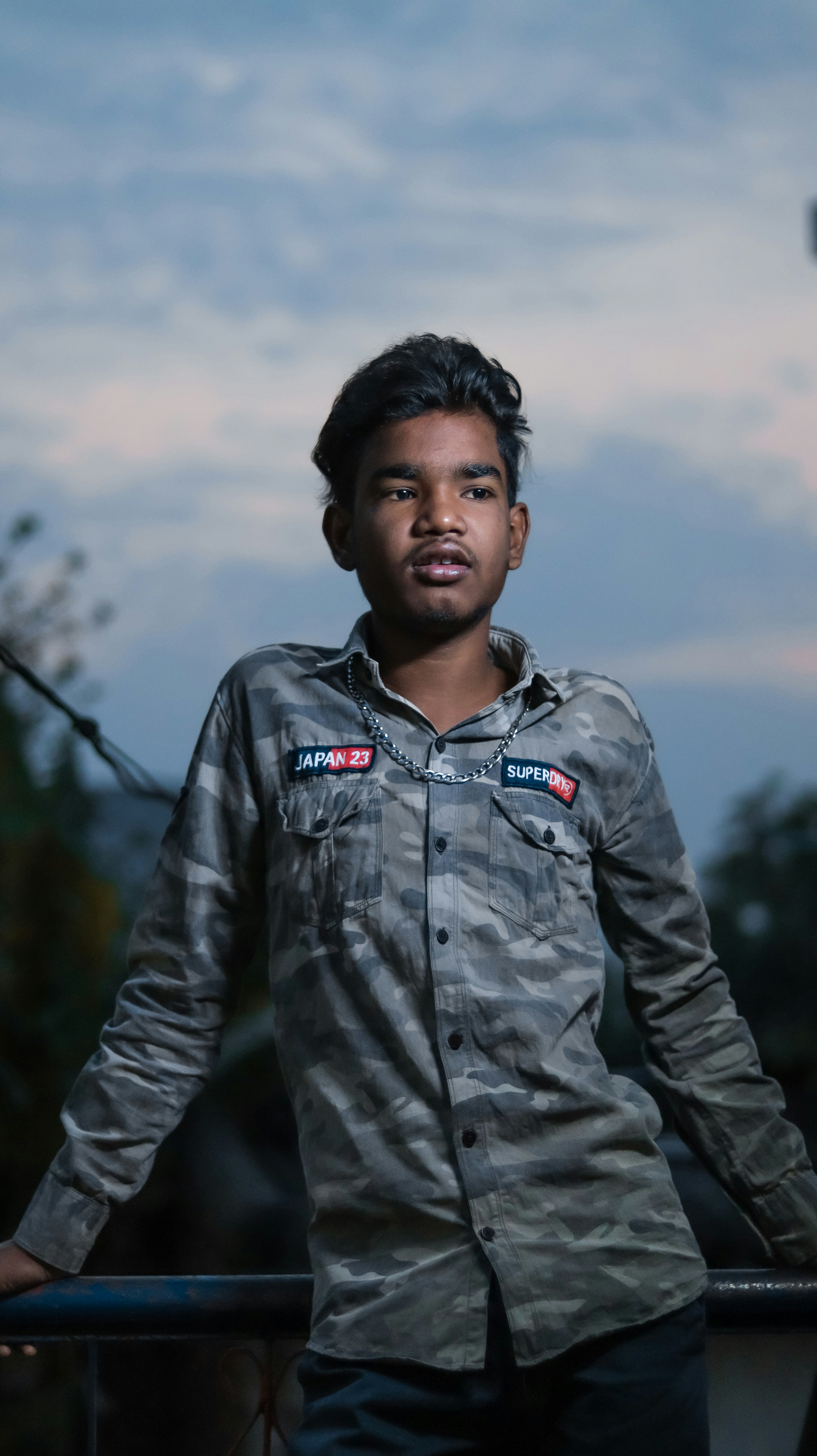 A man standing next to a fence with his hands on his hips photo – Free ...