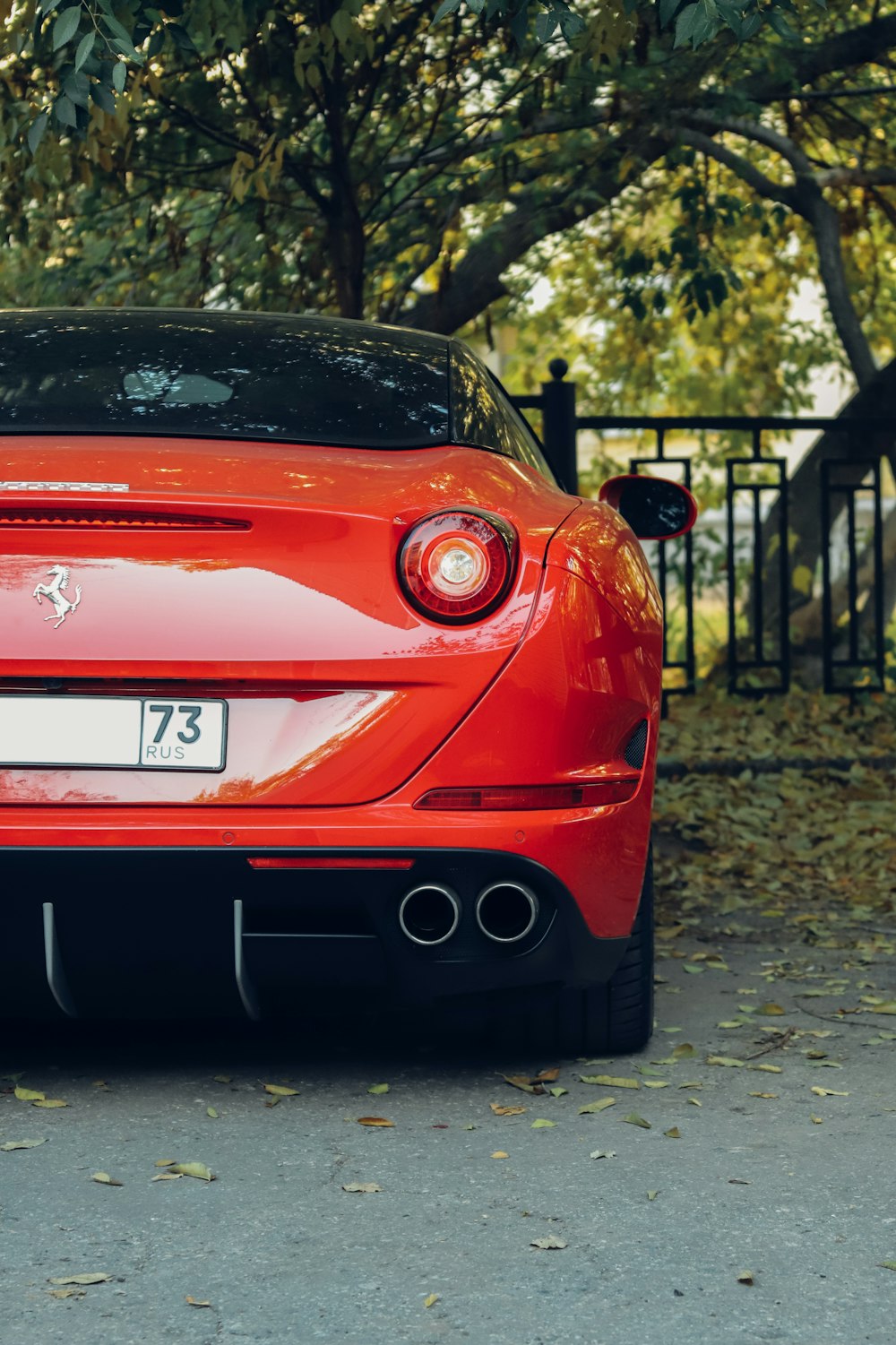 a red sports car parked in front of a fence