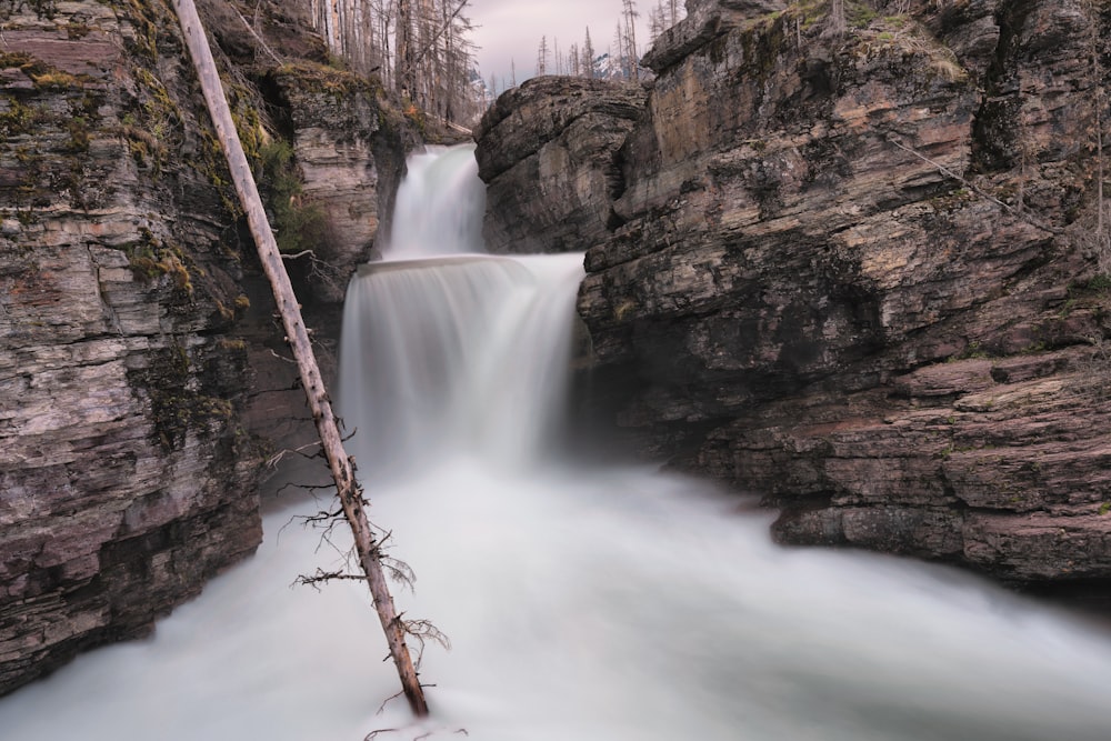 a long exposure photo of a waterfall in the woods