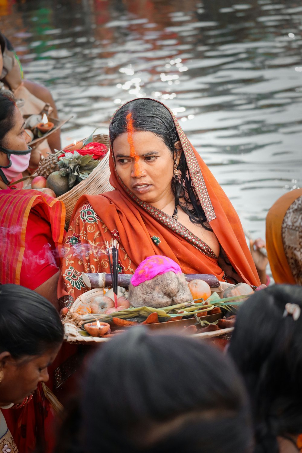 uma mulher em um sari sentado em um barco em um corpo de água