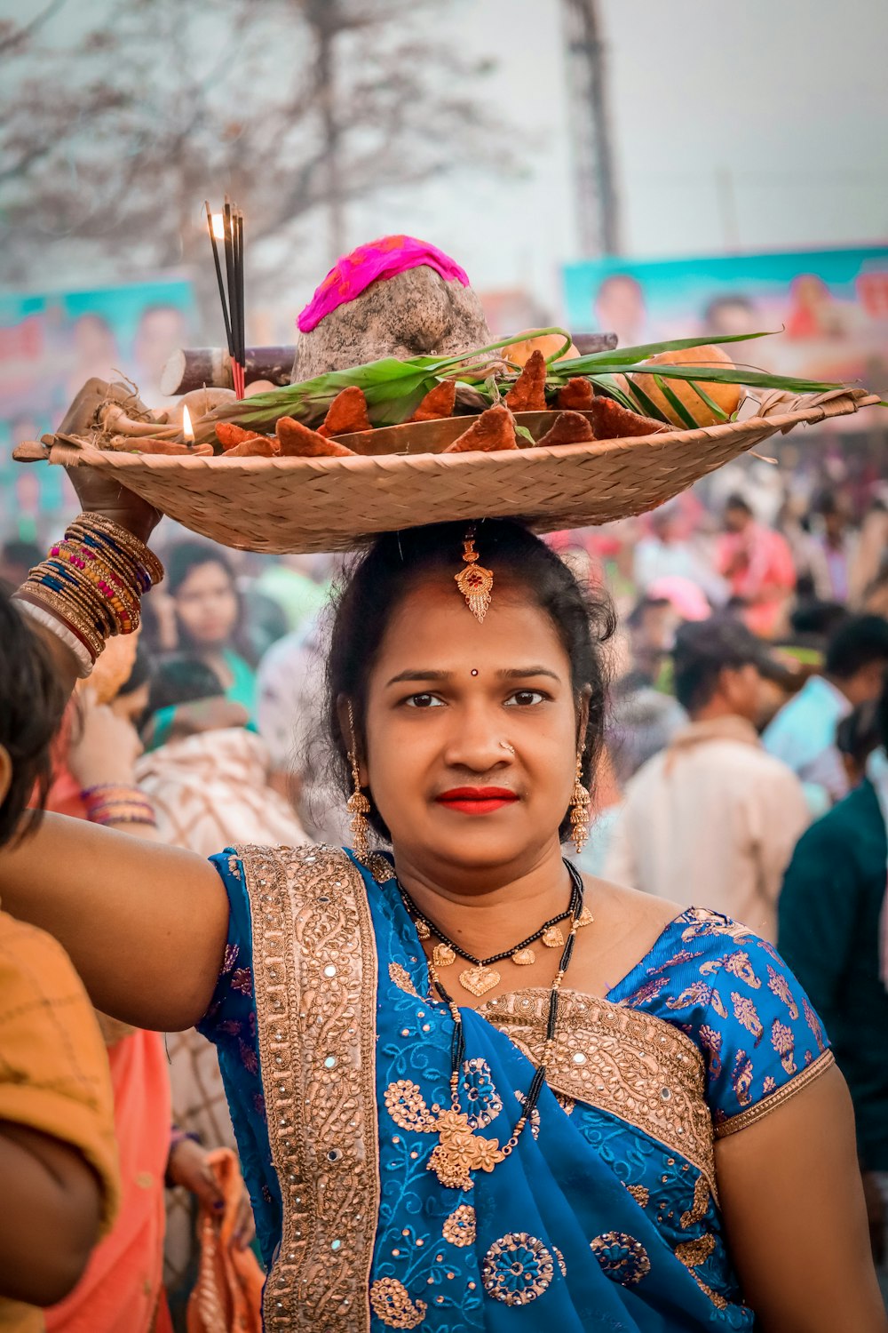 a woman carrying a tray of food on her head