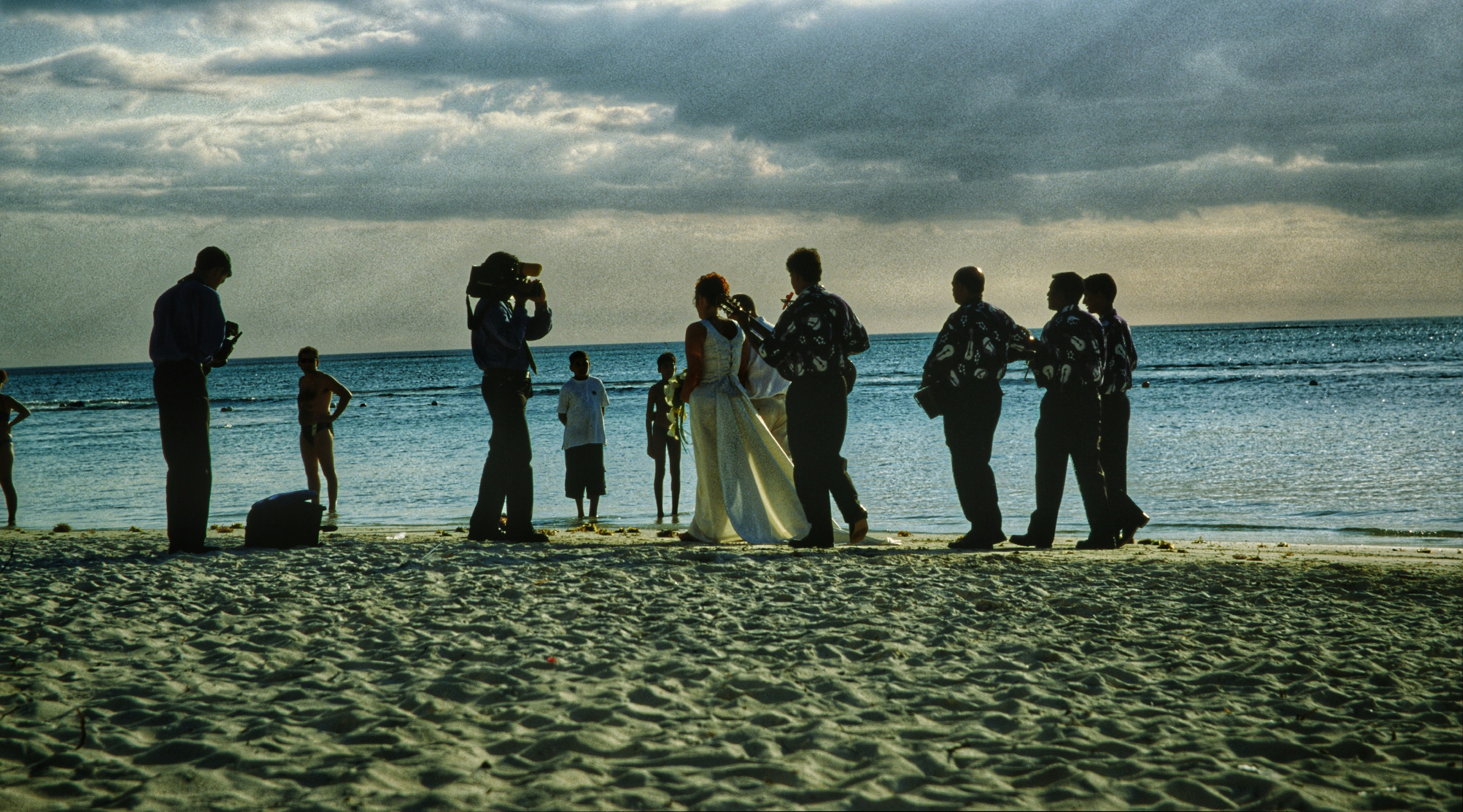 a group of people standing on top of a sandy beach