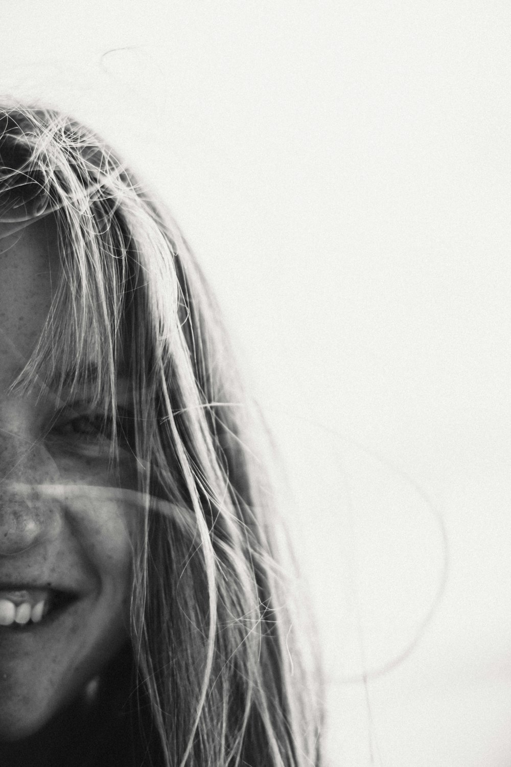 a black and white photo of a woman smiling