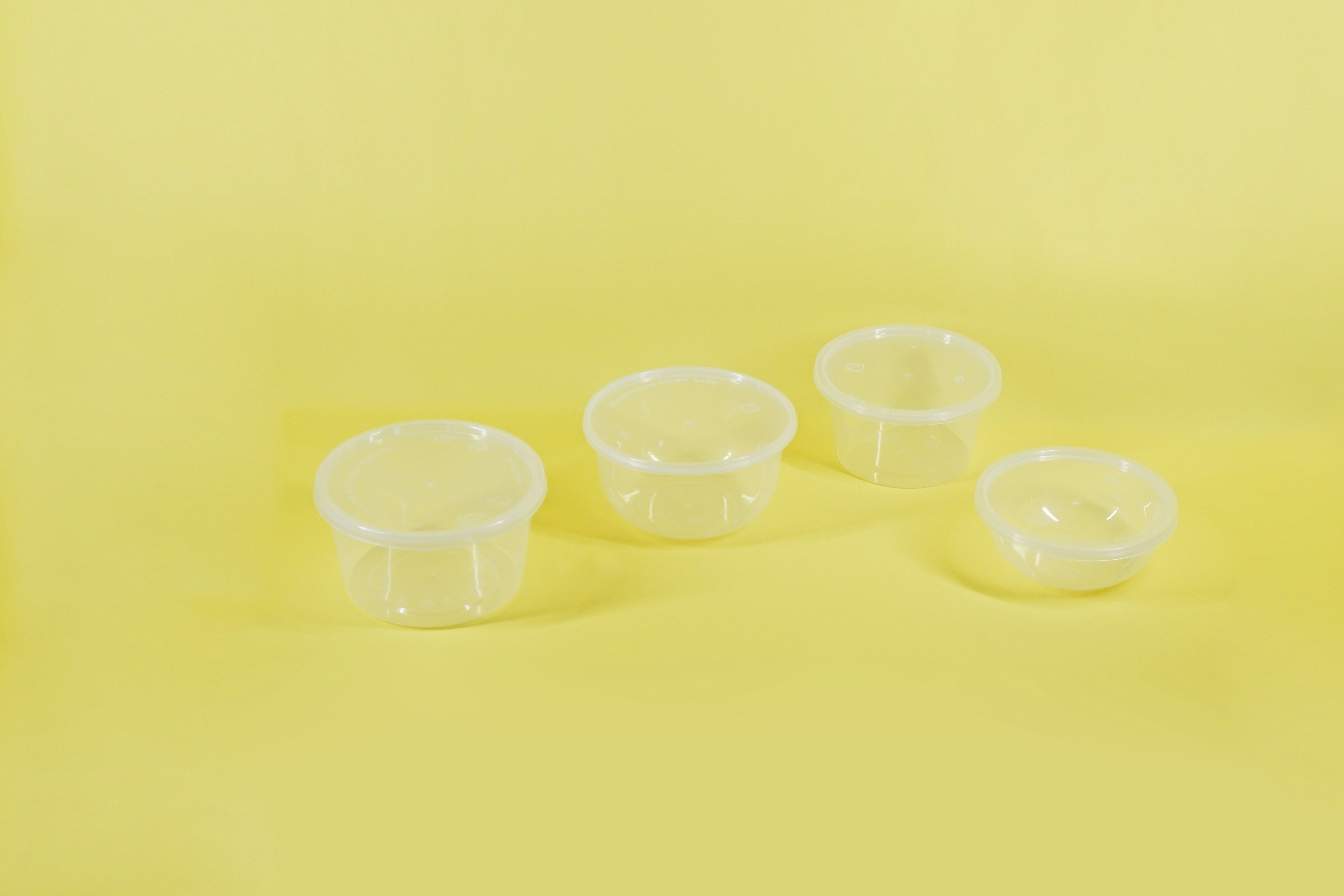 a group of three plastic containers sitting on top of a yellow surface