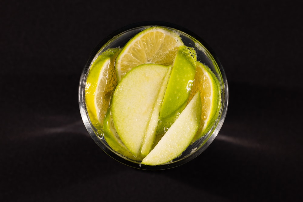 a glass filled with green liquid and sliced apples