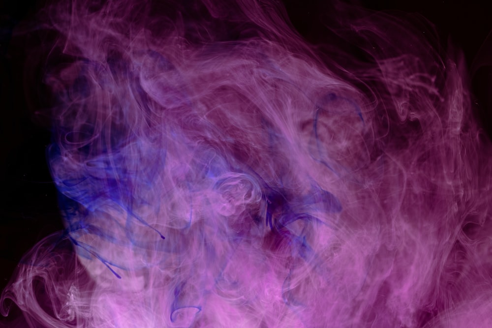 a close up of purple smoke on a black background