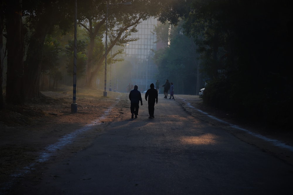 a group of people walking down a dirt road