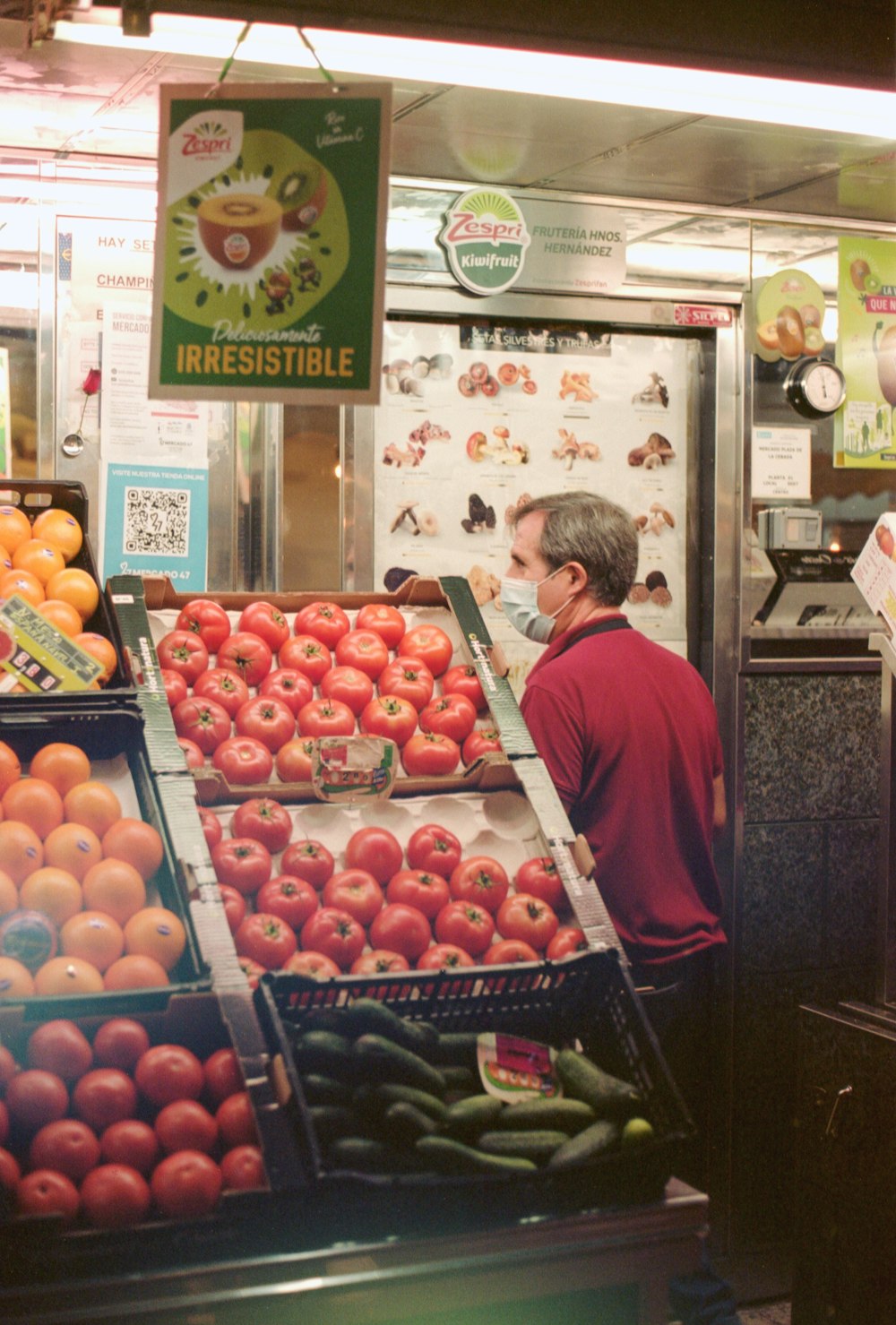 a man standing in front of a display of fruits and vegetables