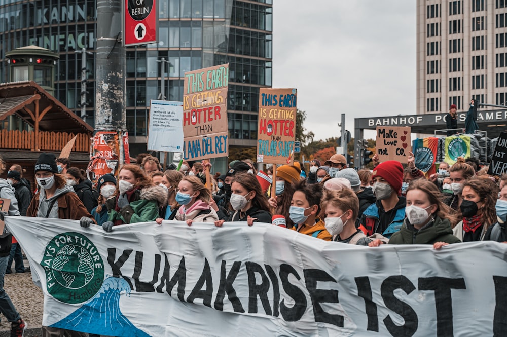 a large group of people holding a protest sign