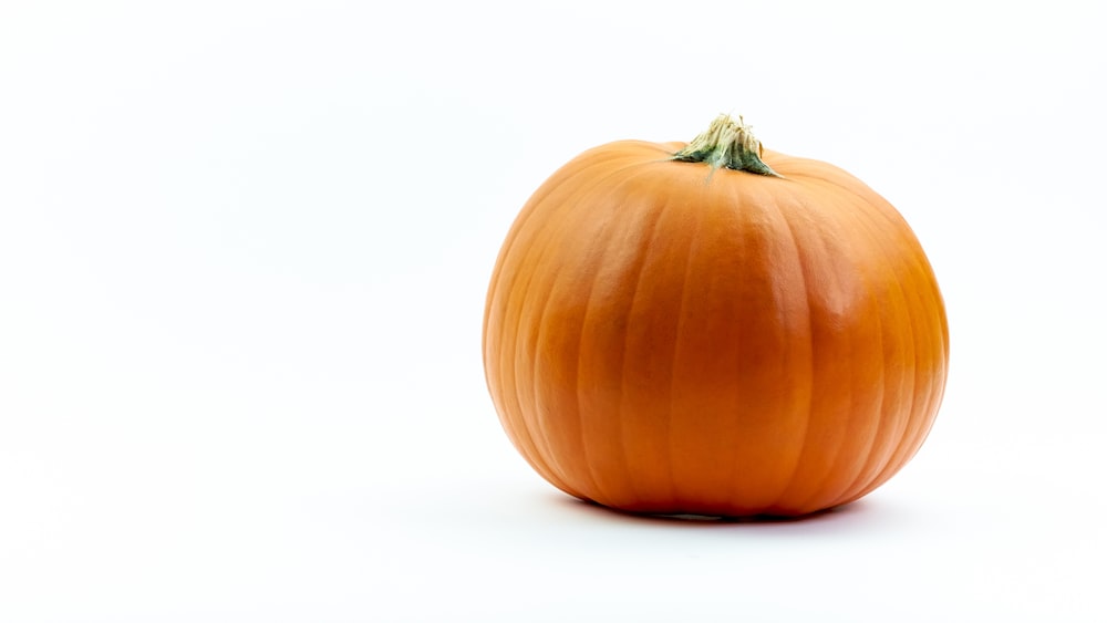 Una gran calabaza naranja sobre un fondo blanco