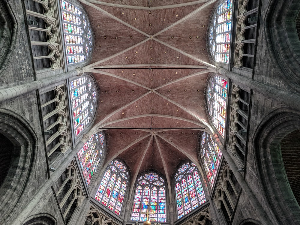 the ceiling of a cathedral with stained glass windows