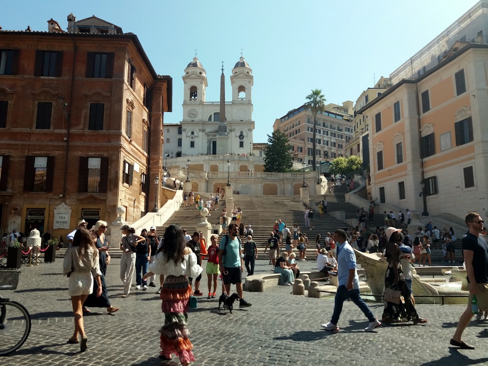 Un gruppo di persone che camminano lungo una strada accanto a edifici alti