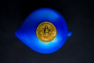 a bit coin sitting on top of a blue vase