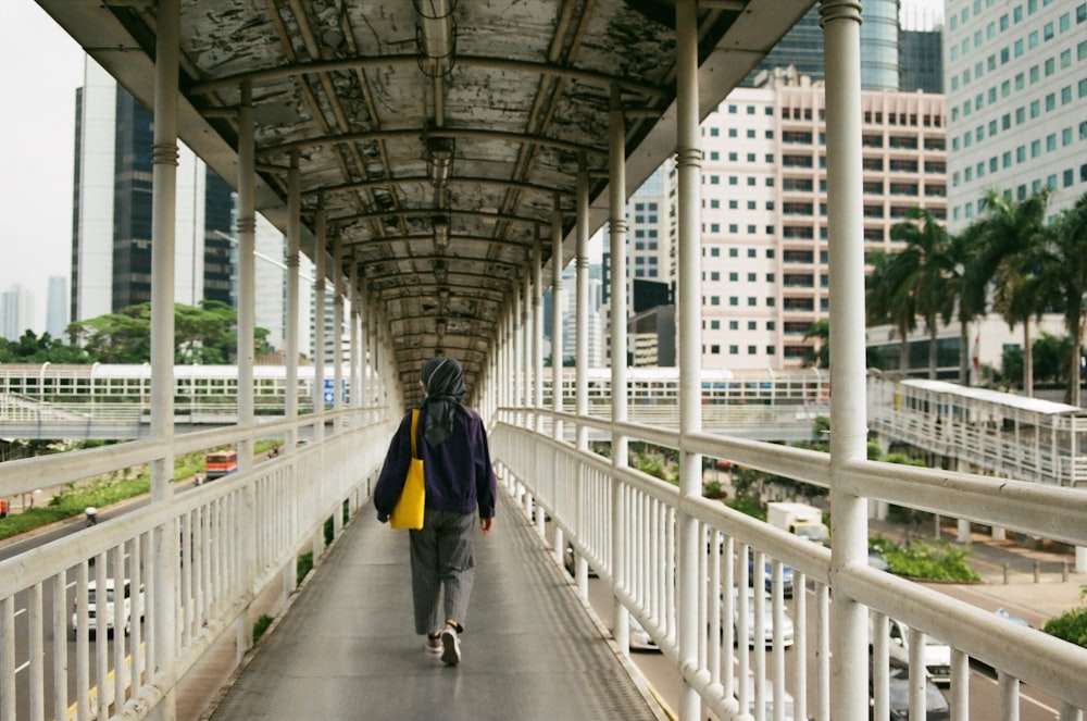 a person walking down a walkway in a city