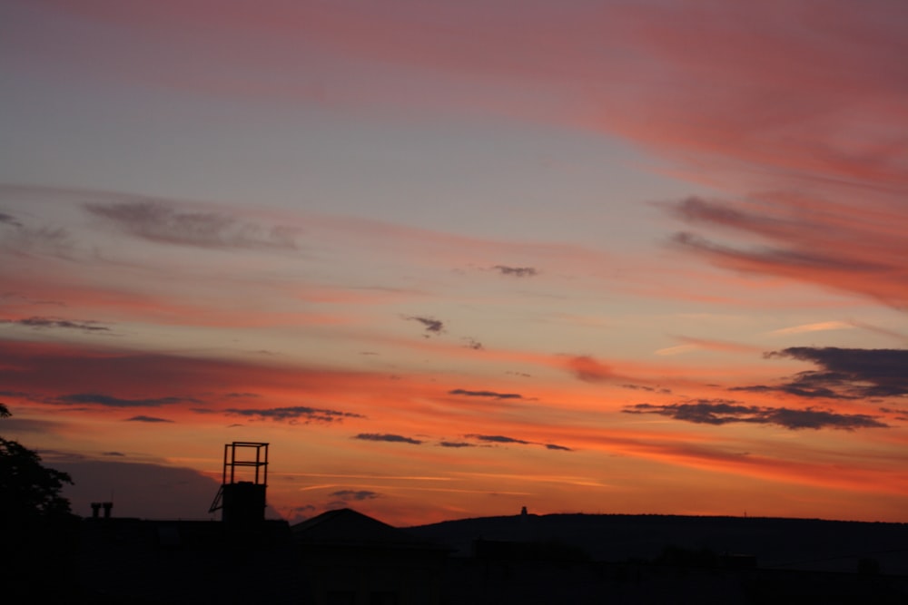 a sunset with a tower in the distance